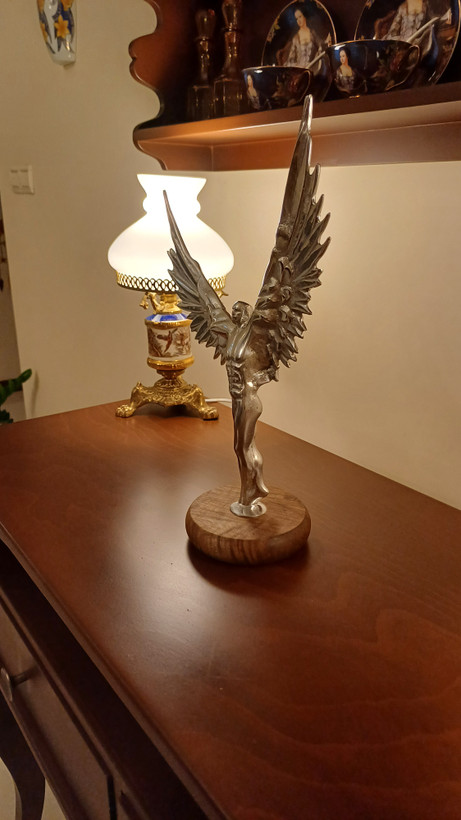 Close-up detail of polished aluminum angel wings on Radten bodybuilder sculpture