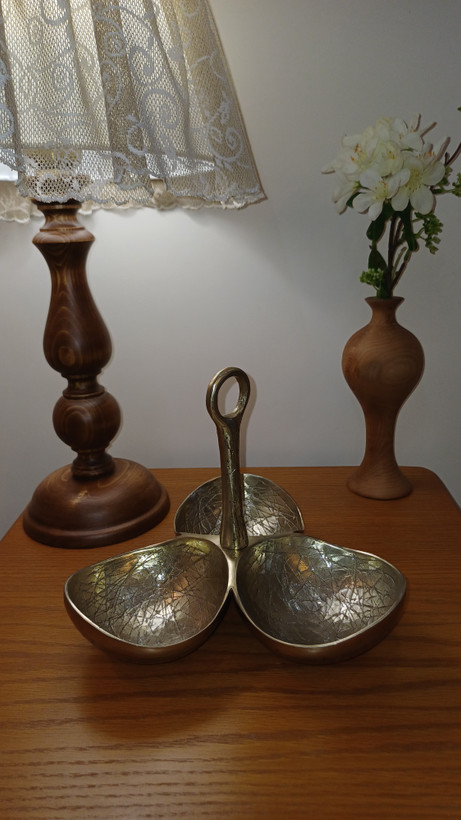 “Close-up of the hammered texture on a handle from the practical and luxurious three-piece dining set.”