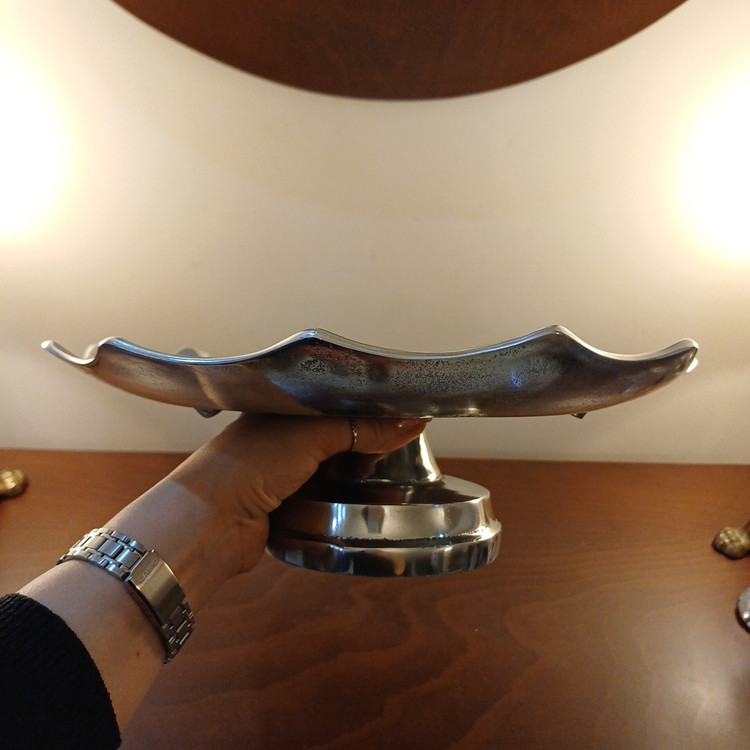 Decorative aluminum pedestal cake plate featuring a sleek linear pattern and metallic finish.
