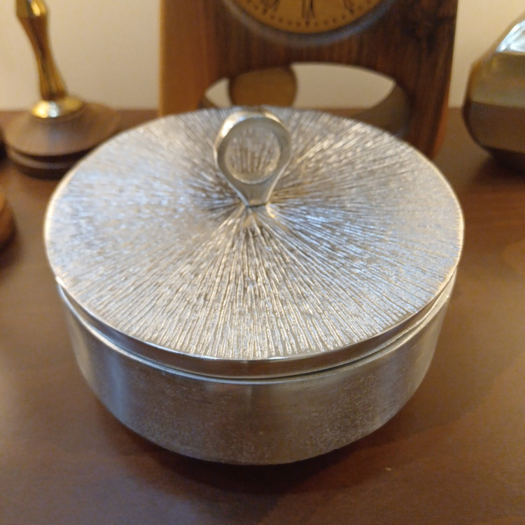 Elegant lidded aluminum chocolate box with a sleek linear pattern and luxurious design.