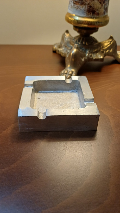 Minimalist modern aluminum ashtray with a polished surface and practical design.