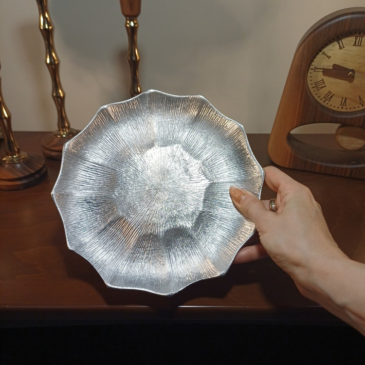 Aluminum serving plate with a linear textured design and a modern elegant finish.
