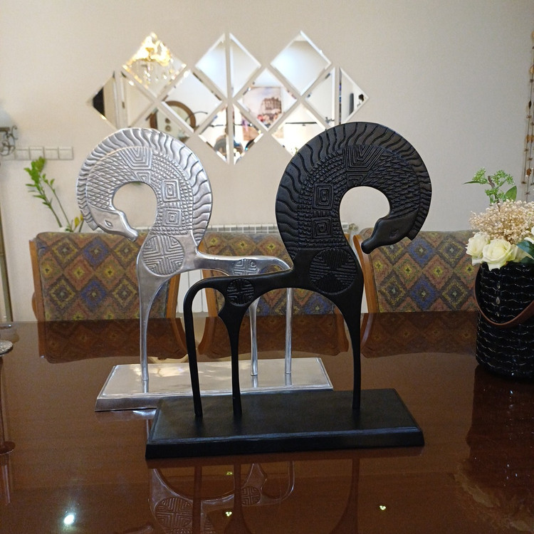 Artistic metal statue depicting a powerful winged horse, featuring a shiny finish and traditional decorative patterns.