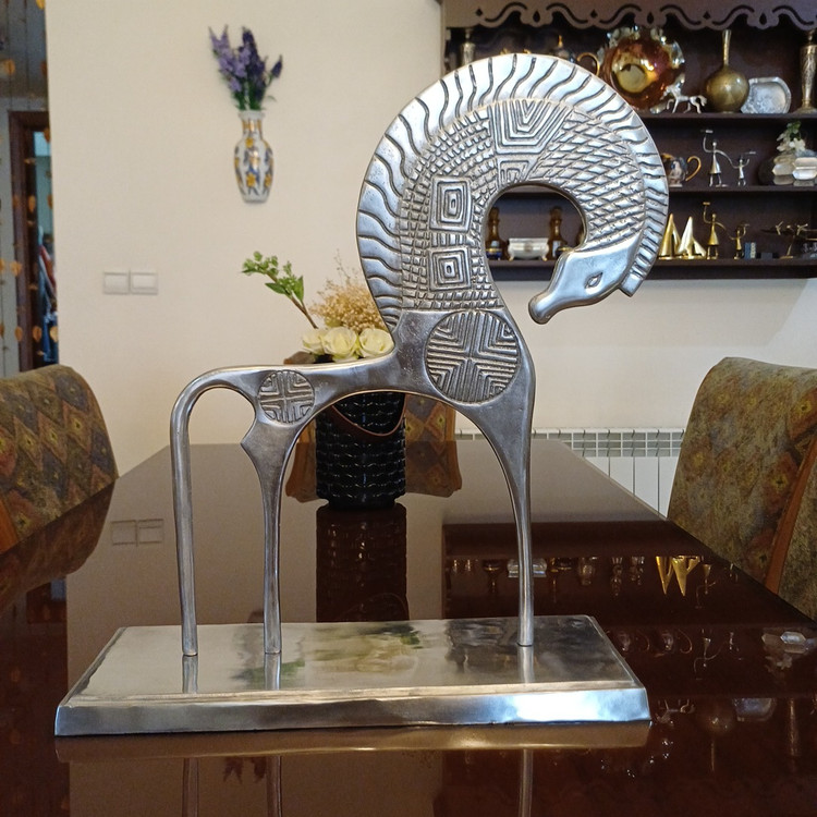 Elegant modern sculpture of a stylized horse with prominent wings and detailed ornamentation on a sleek base.