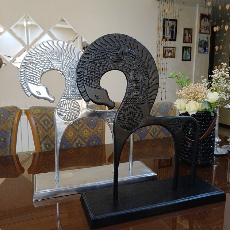 Majestic Art Deco style winged horse sculpture crafted from polished metal with intricate geometric engravings.