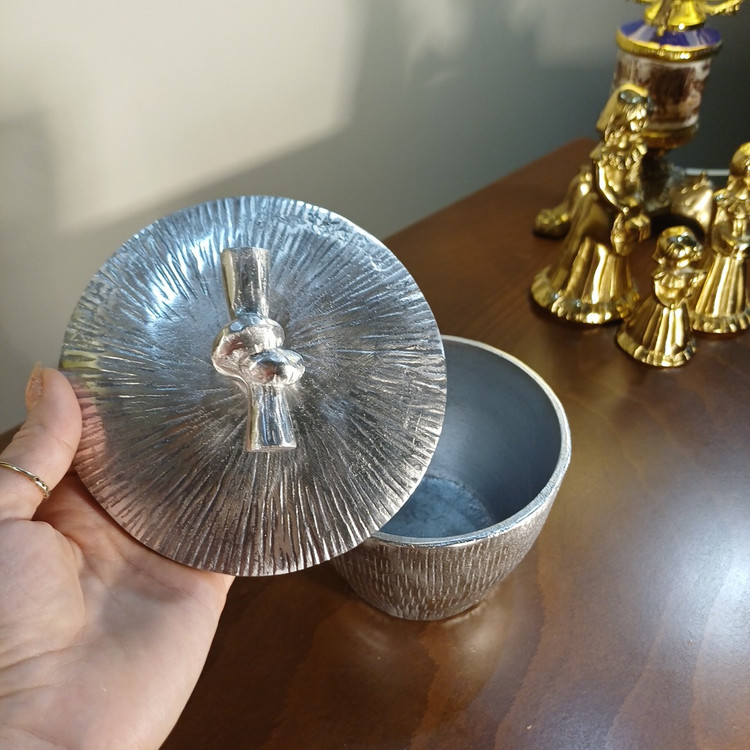 “Elegant aluminum chocolate jar, ‘Gereh’ model. Features textured vertical ribs and a distinctive knot-shaped lid handle.”