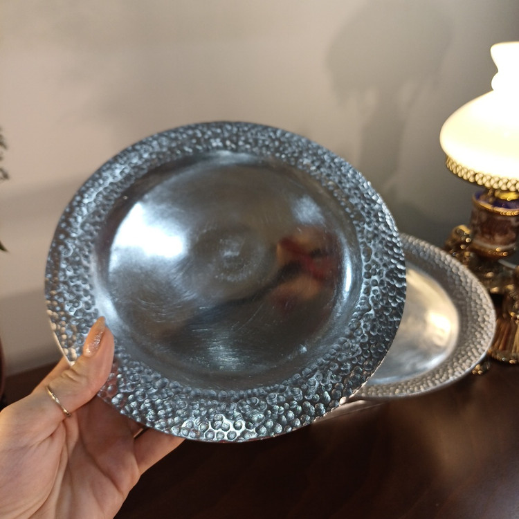 “Medium and large hammered aluminum serving dishes with decorative bases. Modern metallic finish with classic hammered detail.”