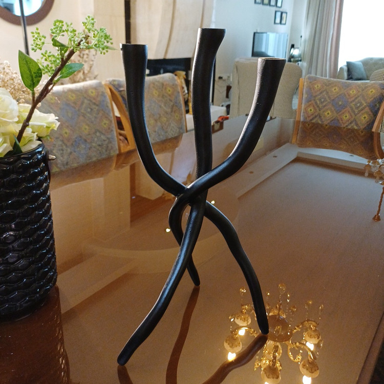 Artistic black metal candle holder with modern minimalist design
