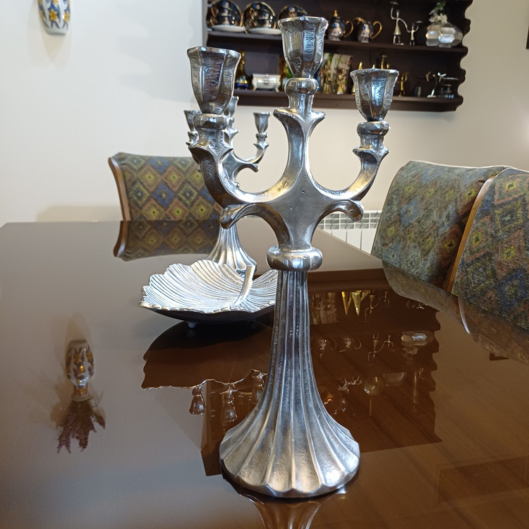 Large Selene 3-arm aluminum candelabra with stand on a modern dining table