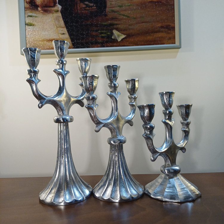 Elegant 3-lite aluminum pillar candelabra placed as a centerpiece on a modern dining room table setup.