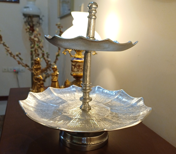 Luxury two-tier aluminum serving stand with pedestal base and linear pattern for elegant table presentation.